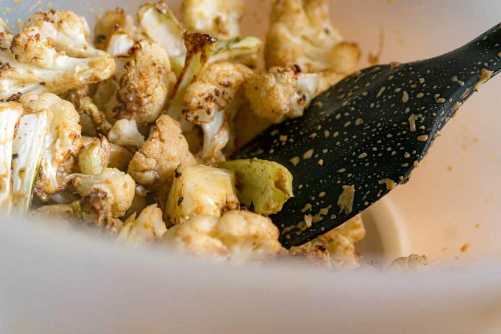roasted cauliflower tossed in a bowl with nutritional yeast and Zhenjiang vinegar