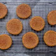 8 turmeric cookies on a cooling rack, with a dark grey background
