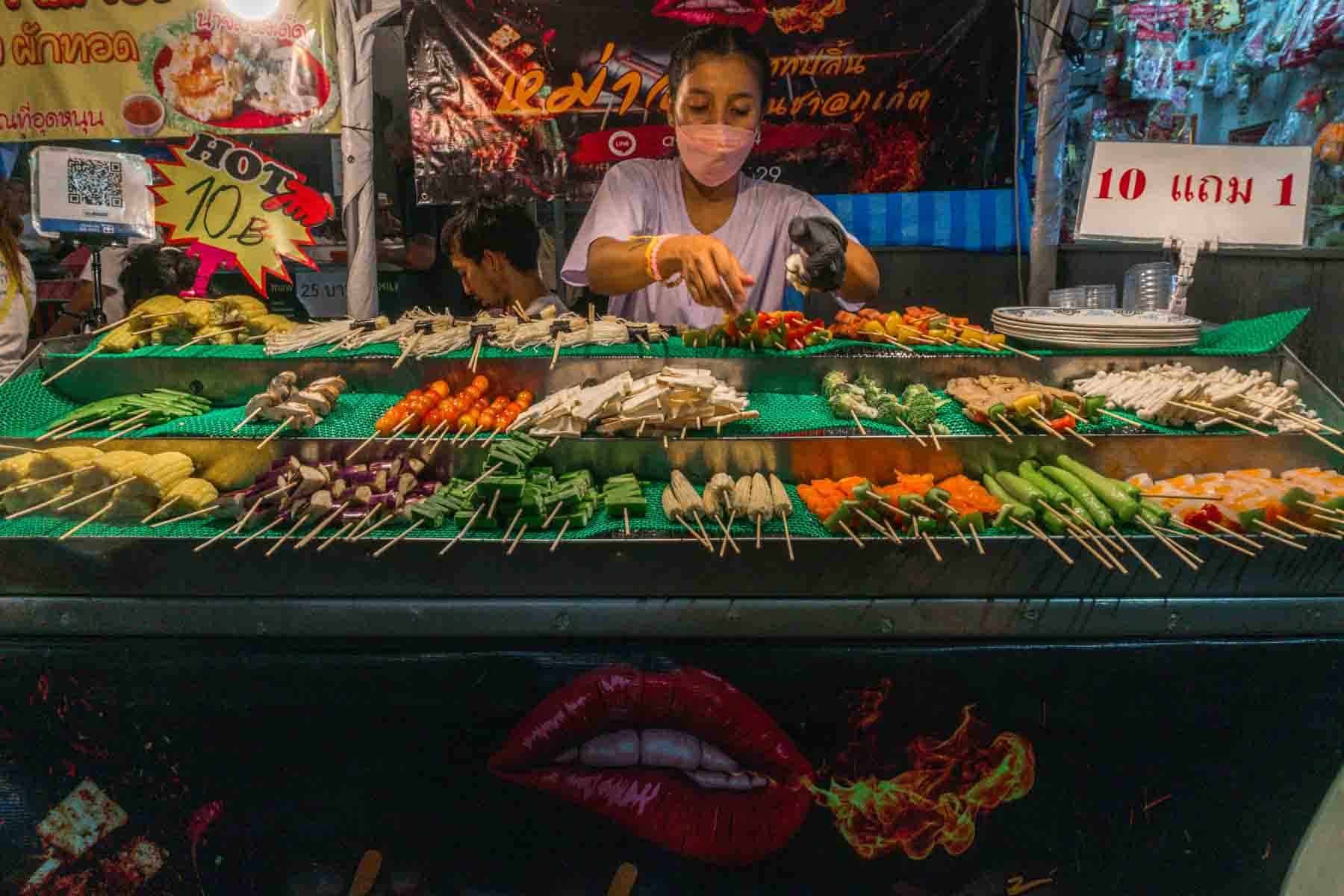 Huge selection of vegetables on skewers, laid on a three tier hawker cart